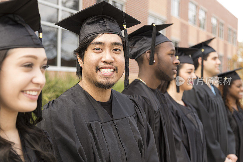 教育背景:大学校园里，毕业生们站成一排。
