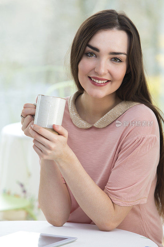 坐在咖啡馆里的年轻女子