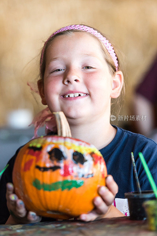 微笑的小女孩展示她画好的南瓜