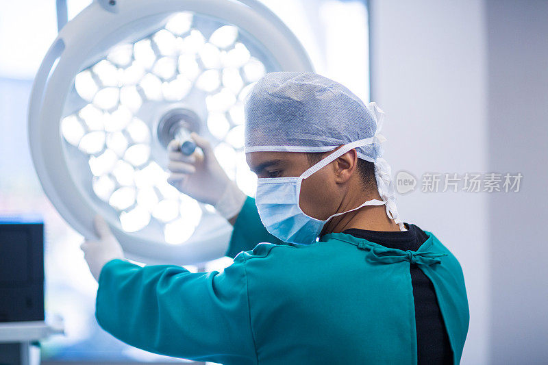 外科医生在手术室调整手术灯