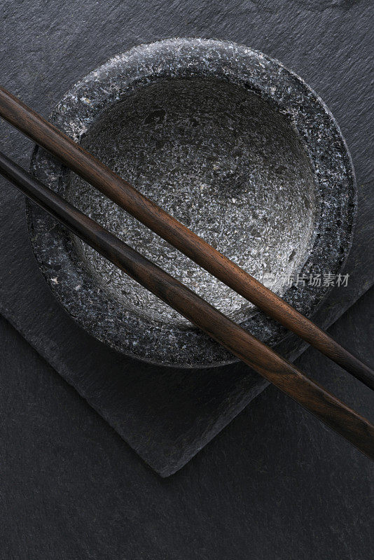 黑色花岗岩碗上的棕色筷子