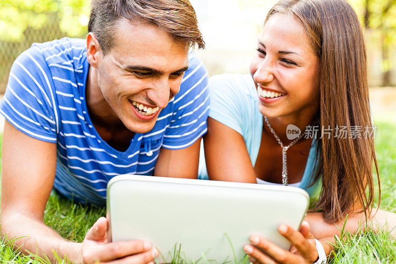 一对年轻夫妇在户外使用数码平板电脑