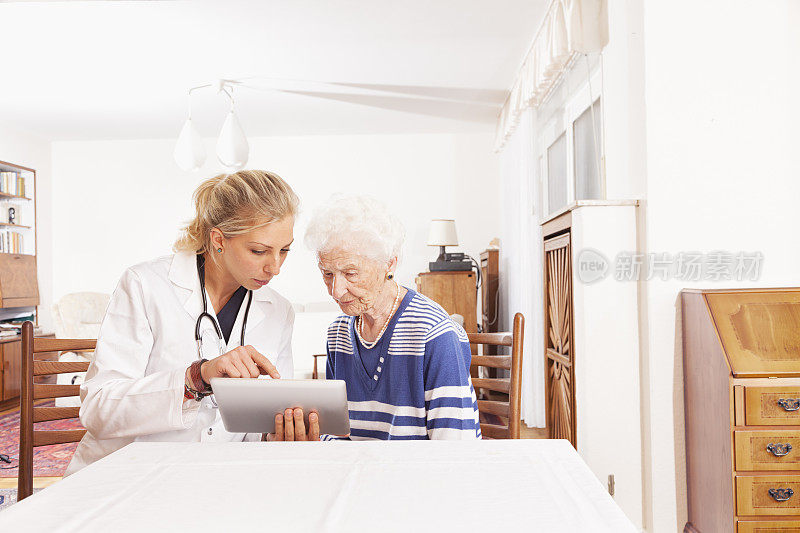 老年女青年医生家访数码平板电脑