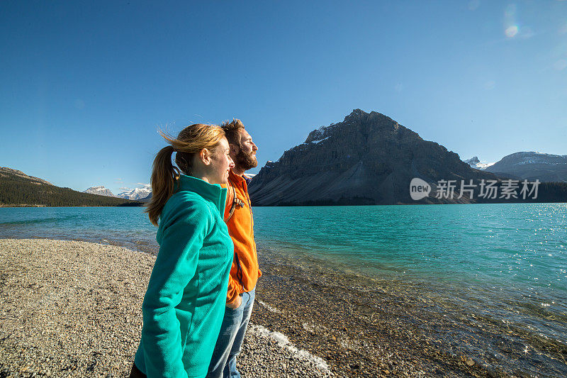 一对愉快的年轻夫妇在湖边放松。