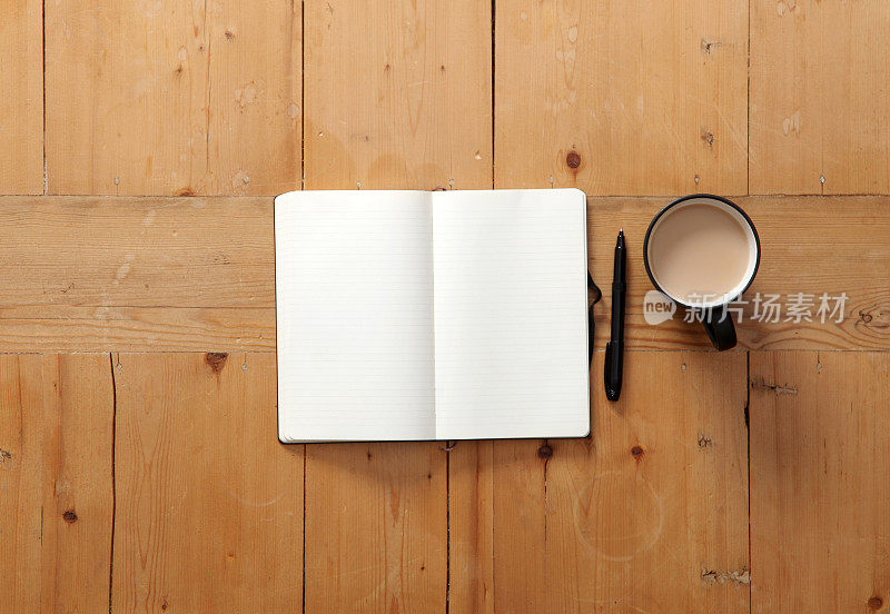打开一本空白的书，桌上有一支笔和一杯咖啡