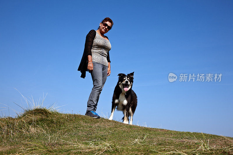 成熟的西班牙女人站在草海岬上