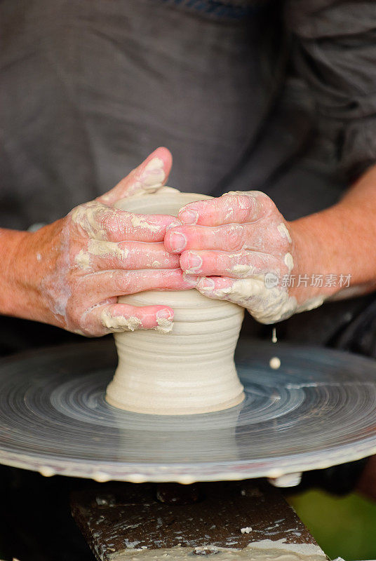 手在陶轮上塑造一个壶