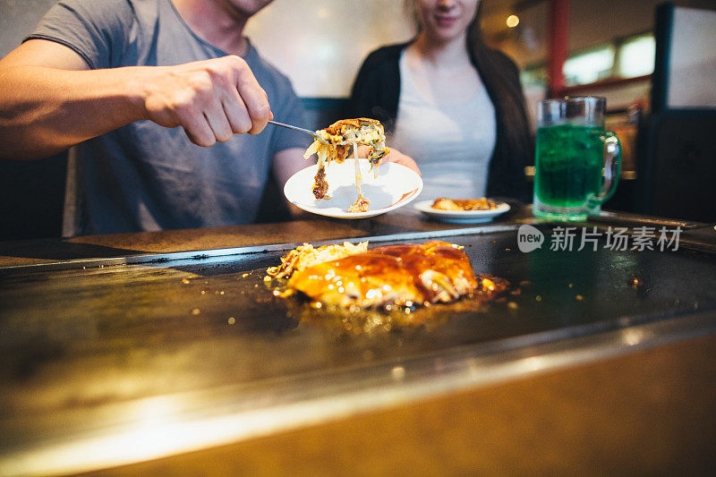 年轻夫妇在自助餐厅吃异国情调的食物