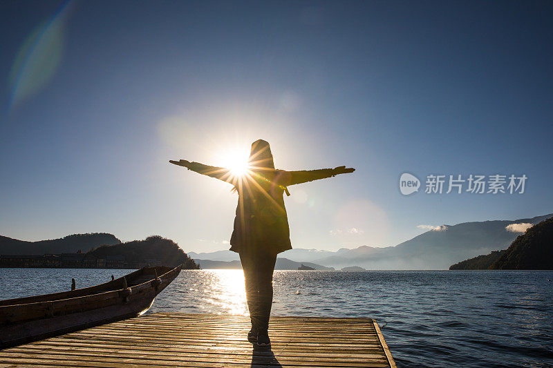 站在湖边码头上的女人