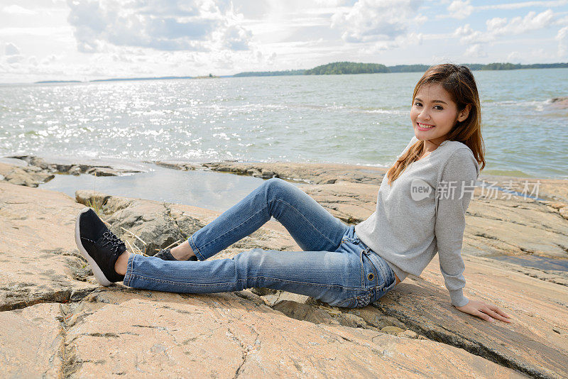 年轻美丽的亚洲女人对风景如画的湖在图尔库芬兰