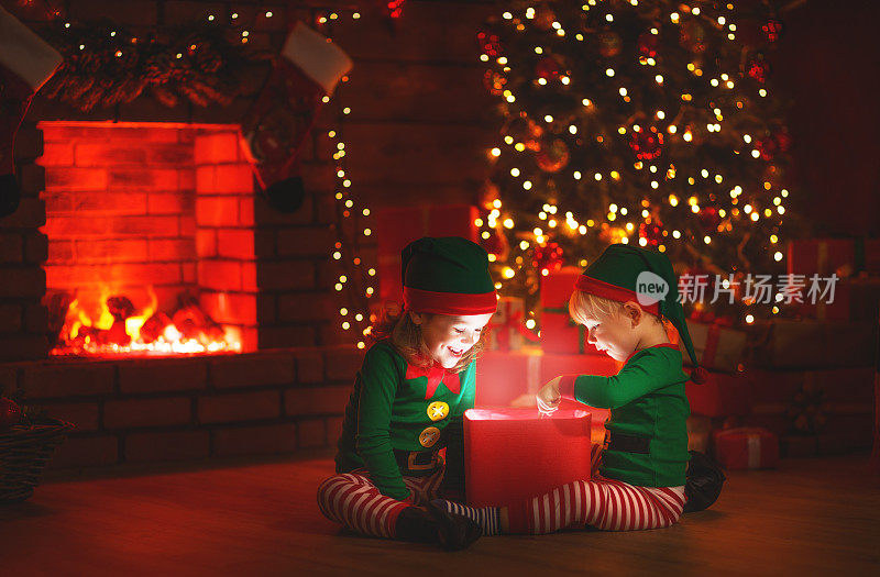 圣诞节。小精灵们在圣诞树和壁炉旁带着一份神奇的礼物