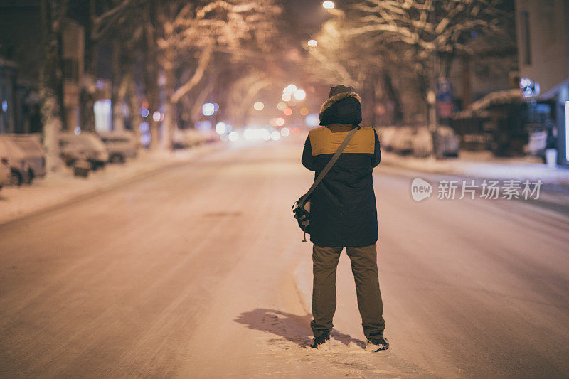 一个人走在雪夜的街道上