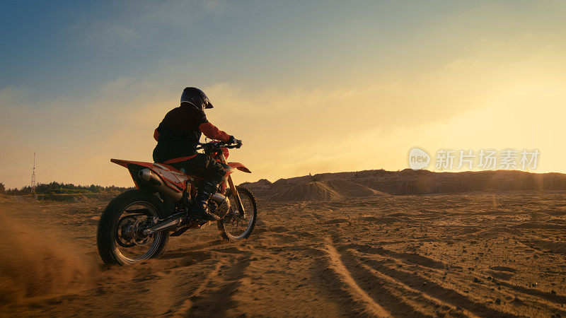 拍摄的职业摩托车越野赛车手骑着他的FMX摩托车在极端越野地形轨道上。