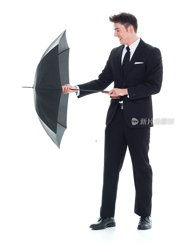 英俊的年轻商人傻乎乎地拿着一把伞
