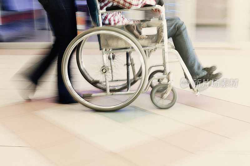 护理人员推着轮椅穿过瓷砖地板