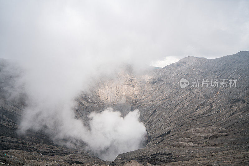 在印度尼西亚东爪哇岛的布罗莫山国家公园，布罗莫火山口边缘有蒸汽。旅游目的地冒险的自然概念