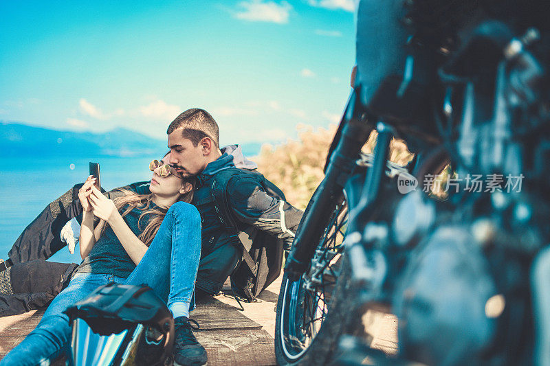 美丽的夫妇在骑摩托车前检查地图