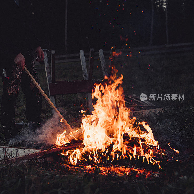 人在户外燃烧木材废料，傍晚处理可燃废料