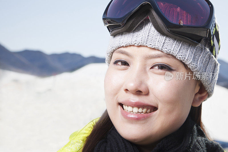 微笑的中国滑雪者戴着护目镜