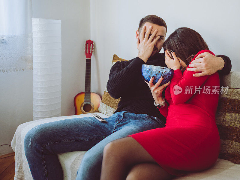 一对年轻夫妇在家里看恐怖电影