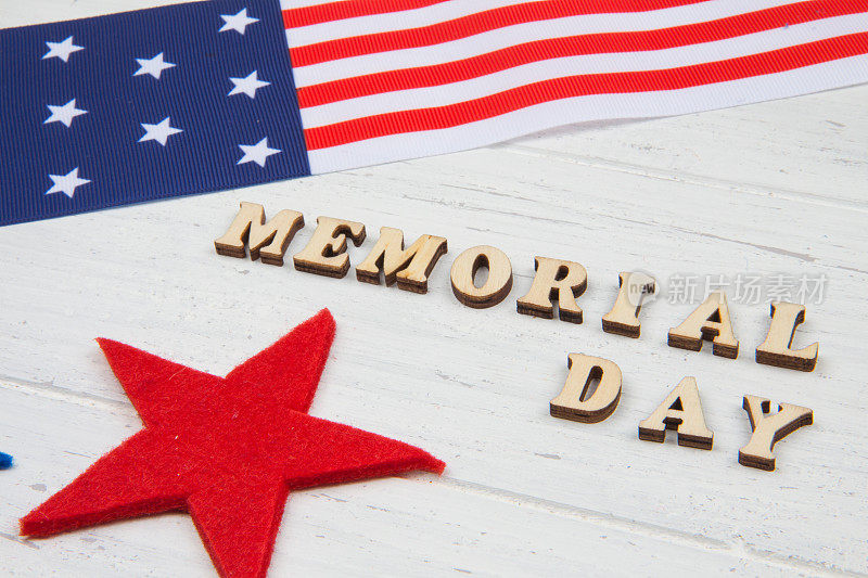 阵亡将士纪念日快乐。文字，星星和美国国旗在白色木制背景