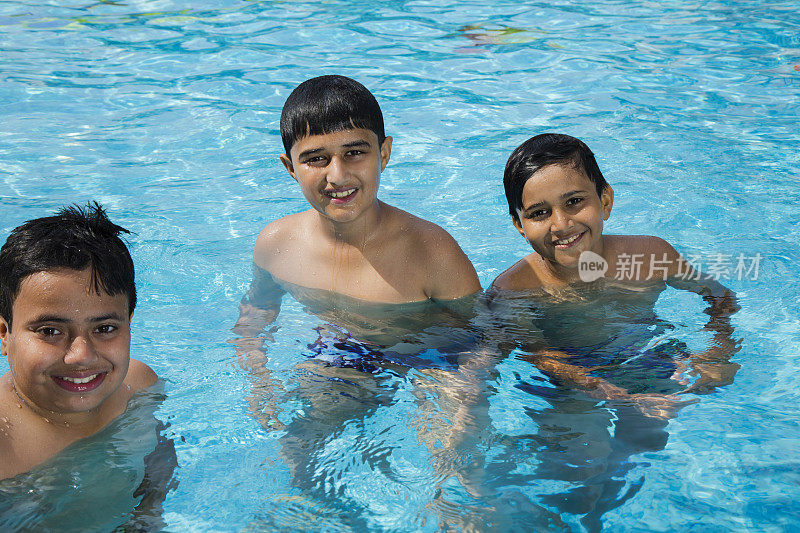 一群青少年朋友在游泳池里玩-股票形象