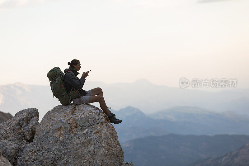 登山者在山顶使用智能手机