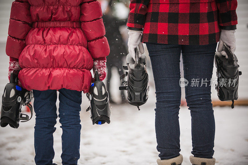 女人和小孩拿着溜冰鞋