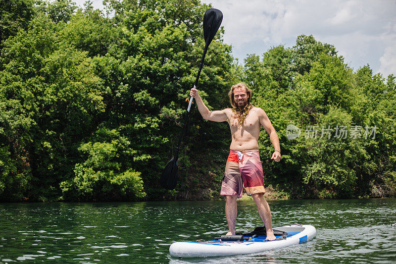 长头发和胡须的男子在湖上和其他人打招呼