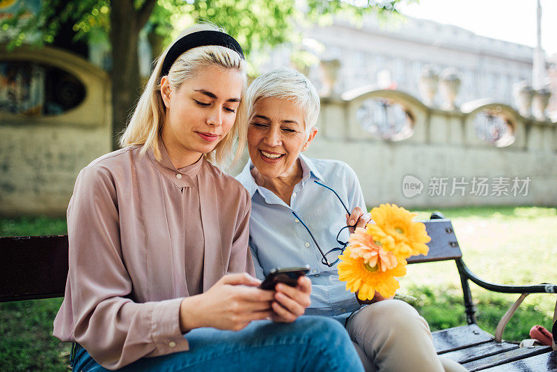 在公园里看智能手机的女人