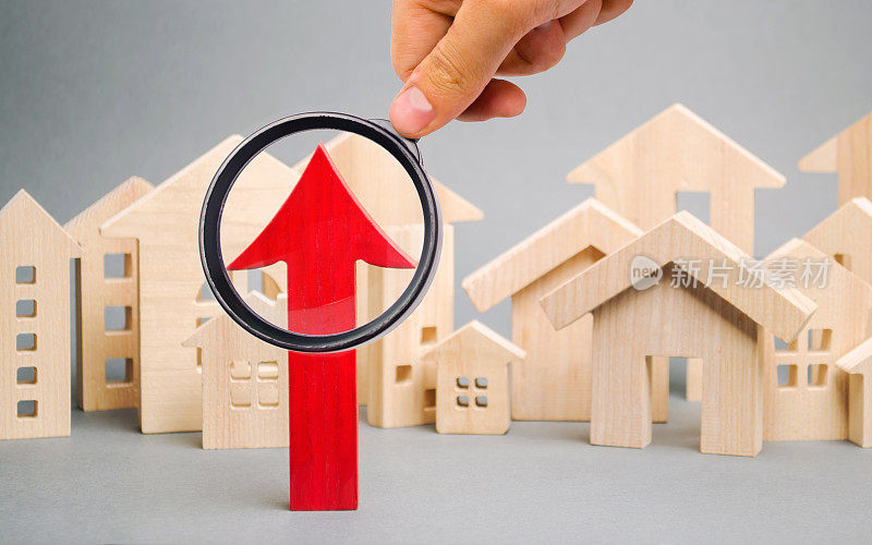 红色箭头向上是微型木屋。房地产价格上涨的概念。抵押贷款利率高。昂贵的租金的公寓。不断增长的购房需求。城市的人口增长。