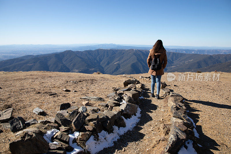 美丽的女人徒步登山在冬季或秋季在加泰罗尼亚(图罗德尔家-西班牙)与拷贝空间