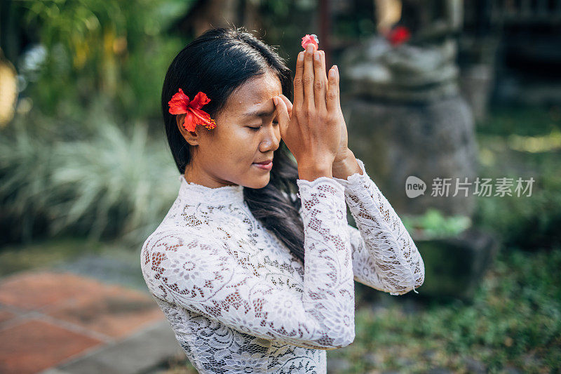 穿着印尼传统服装祈祷的亚洲妇女