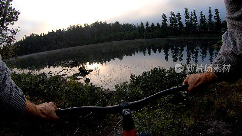 日出时分，人们沿着湖边小径骑车