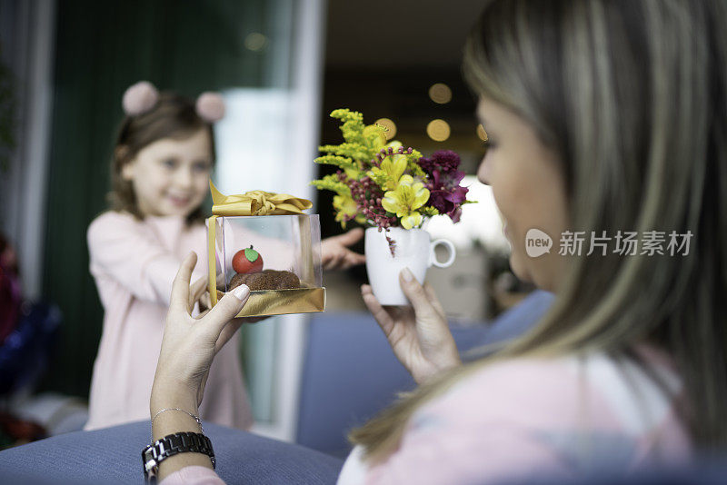 女孩送礼物给妈妈，庆祝母亲节