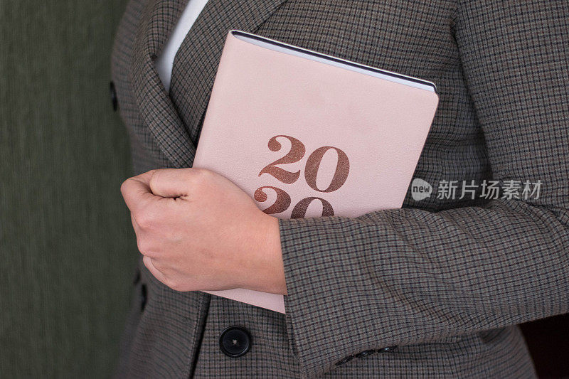 手握2020计划书的特写。制定2020年的新计划