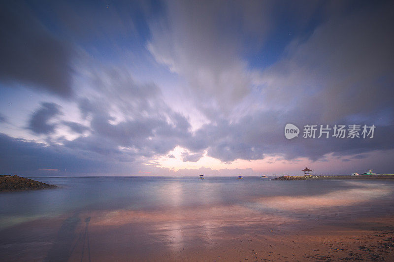 日落附近著名的旅游地标巴厘岛-宽角的热带海滩海景日落在巴厘岛，印度尼西亚的热带自然景观，巴厘岛。