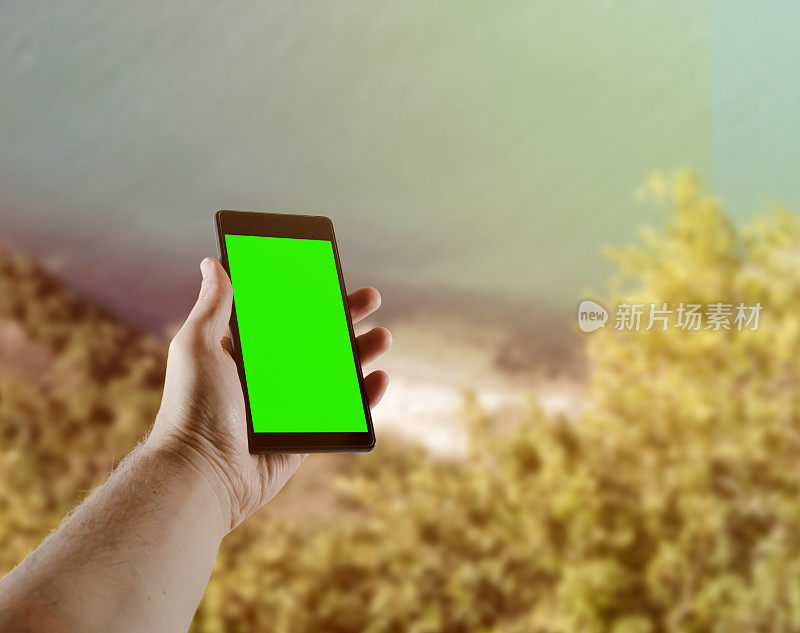 特写在手握手机显示绿色屏幕