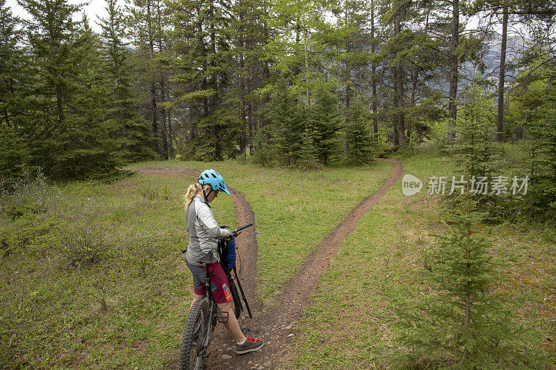 女山地电动自行车手在她的背包之前骑