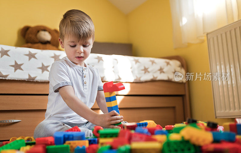 蹒跚学步的男孩在玩积木