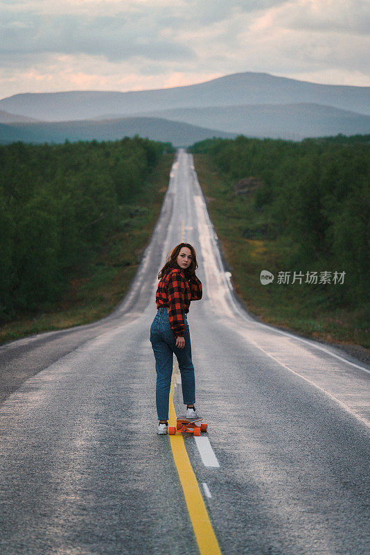 芬兰的一名女子在路上玩长滑板