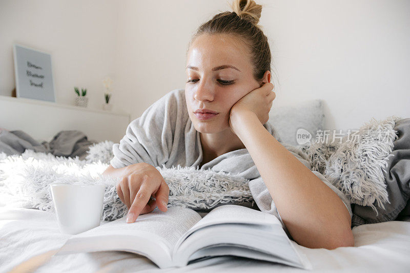 年轻漂亮的女人在家里看书