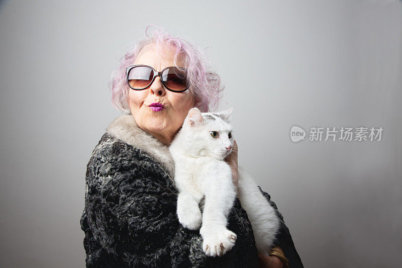 快乐的老年妇女宠物主人抱着她的猫