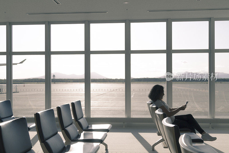 年轻游客独自在机场候机室等候