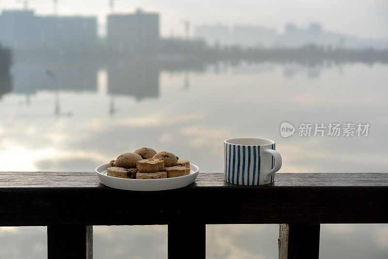 阳台栏杆上放着巧克力饼干和咖啡杯