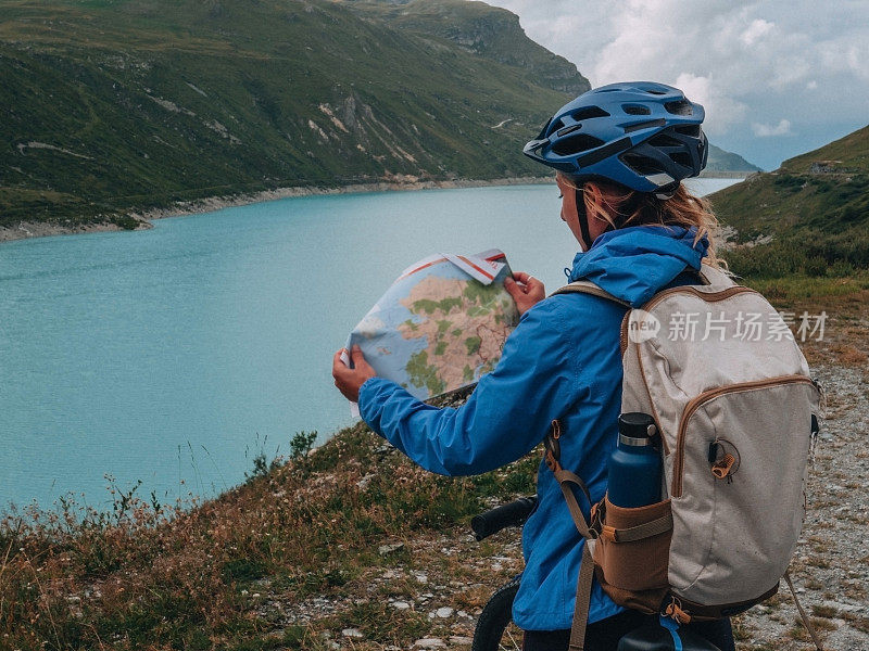 山地车停在美丽的蓝色湖畔高山小径看地图