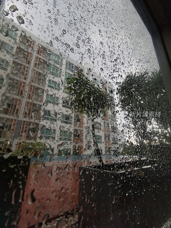 下雨的城市里看到的窗户被雨滴覆盖