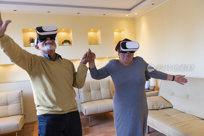 一位老人和他的妻子正在用虚拟现实眼镜浏览一个虚拟世界。