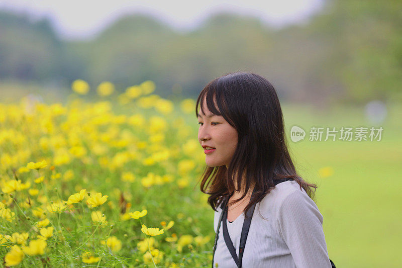 美丽的年轻女子在花田拍照