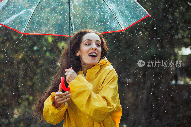 快乐的女人在雨中行走